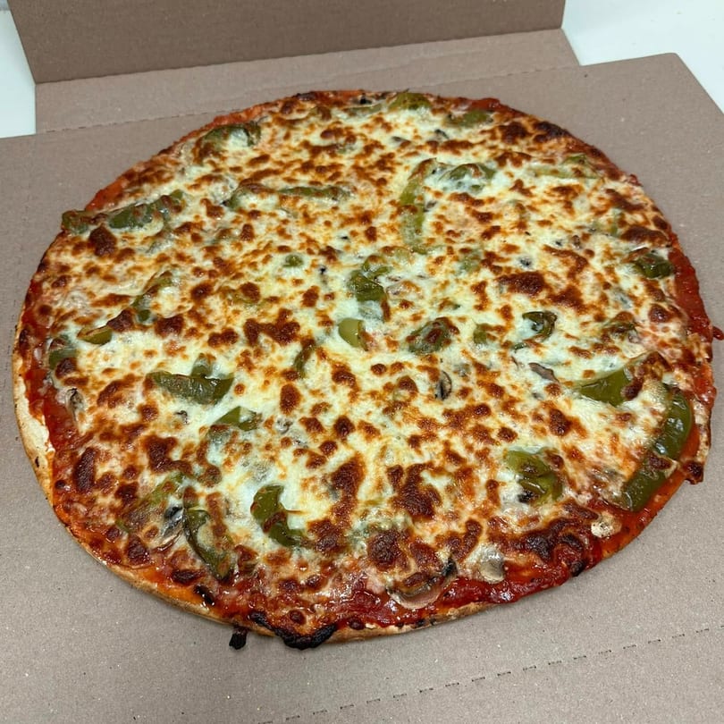 Anthony's Pizzeria's whole pizza with melted cheese, green peppers, and mushrooms in a cardboard box.