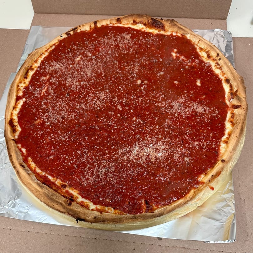 A deep-dish pizza from Anthony's Pizzeria, topped with rich red sauce and grated cheese.